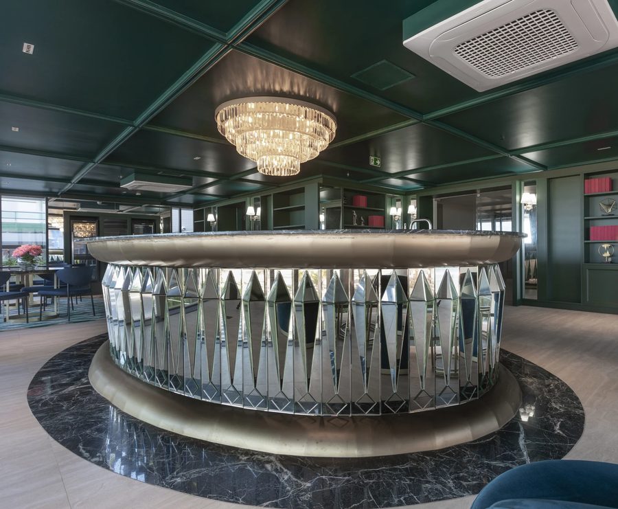 Bar oval do Setai Sandro Barros, com balcão espelhado, lustre de cristal e teto verde